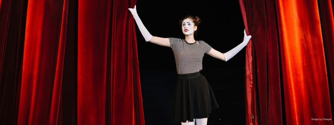  female mime artist holding red curtain
